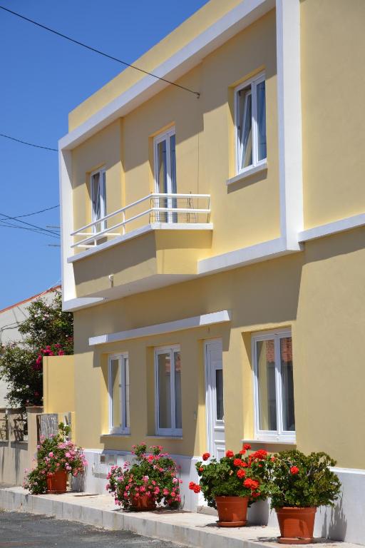 a yellow building with flowers in front of it at VillasFerrel - Cosy Apartment in Ferrel