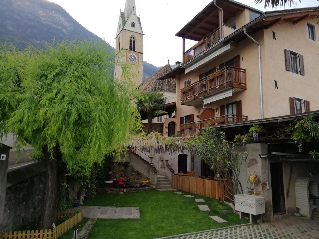 a courtyard of a building with a clock tower at Haus Möltner - Apartment "Weinansetz" in Caldaro