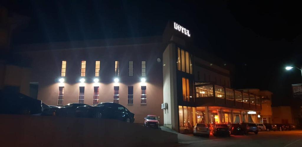 a building with lights on it at night at Hotel Urban in Bužim