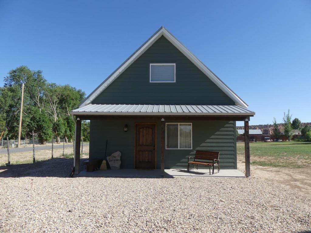 a green house with a bench in front of it at Private, Charming Cabin - Sleeps 5 - The Evergreen - Bryce Canyon National Park in Cannonville