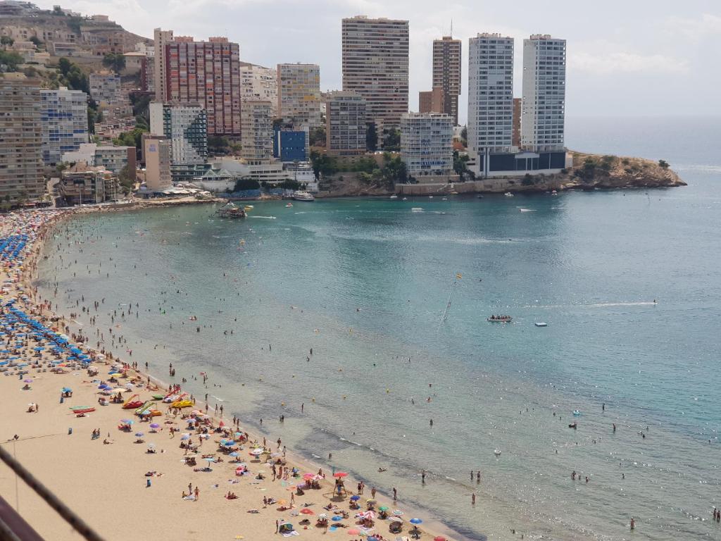 un groupe de personnes sur une plage dans l'eau dans l'établissement Las Damas Piso18, à Benidorm