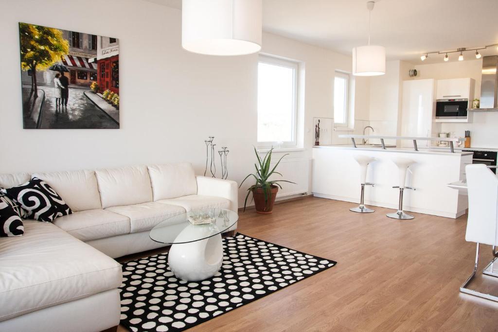 salon z białą kanapą i kuchnią w obiekcie Prostorný 3 pokojový apartmán s dvěma terasami w Pradze