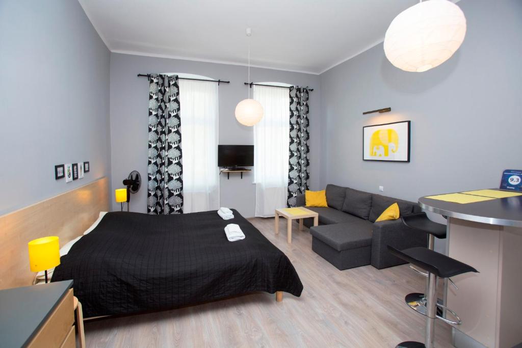a bedroom and living room with a bed and a couch at Apartamenty Sedinum in Szczecin