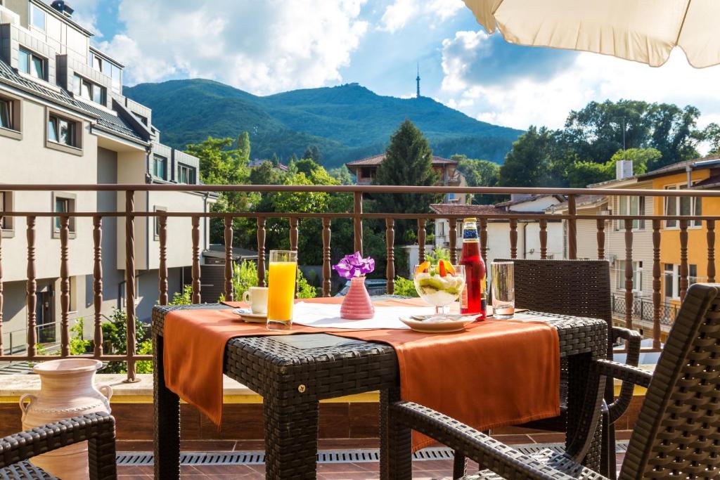 a table on a balcony with a view of a mountain at Hotel Villa Boyana - Free Parking in Sofia