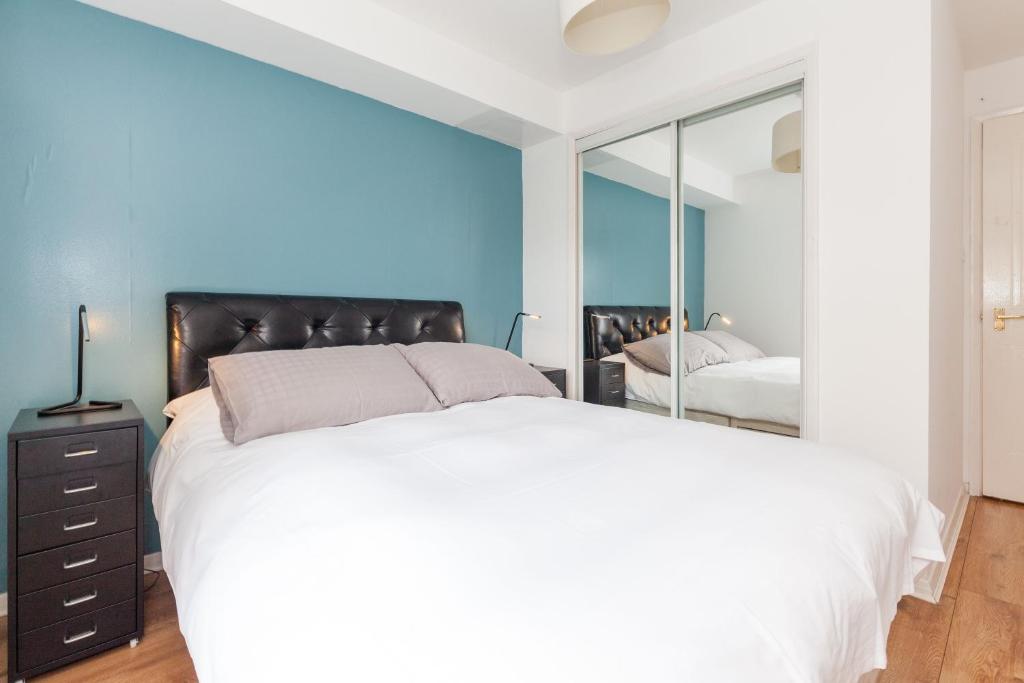 1 dormitorio con 1 cama grande y espejo en Annandale Street Quiet Central Family Apartment with Parking, en Edimburgo