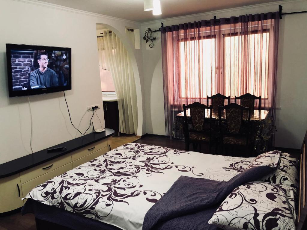 リウネにあるApartment Rovnoのベッドルーム1室(ベッド1台、壁掛けテレビ付)