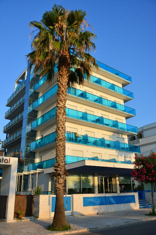 palma przed wysokim budynkiem w obiekcie Hotel Altis w mieście San Benedetto del Tronto