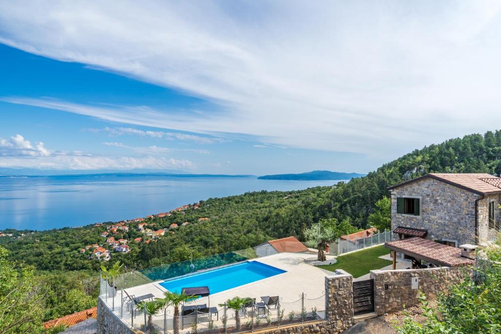 an image of a villa with a swimming pool and the ocean at Villa Visum in Poljane
