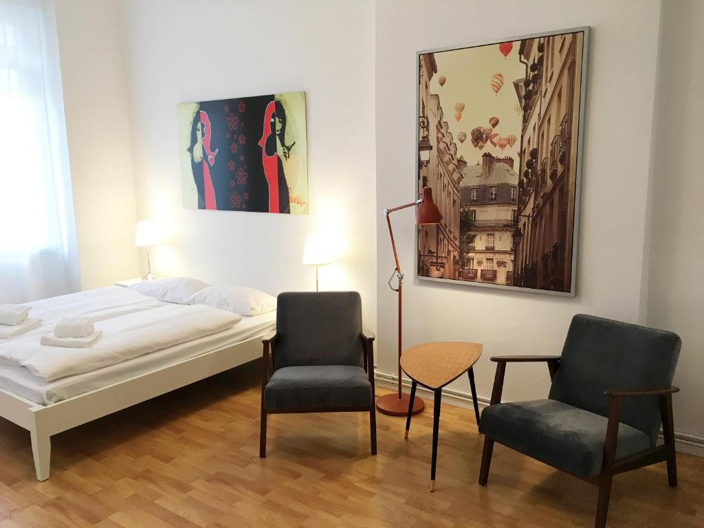 a bedroom with a bed and two chairs at Downtown Apartment Berlin Friedrichshain in Berlin