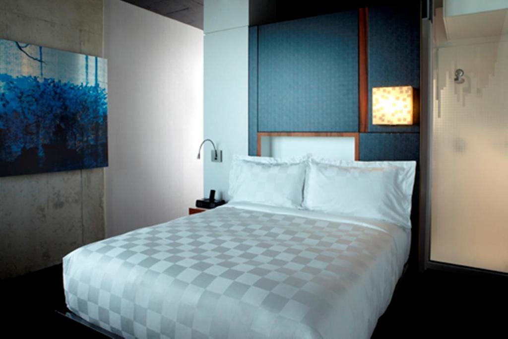 a bedroom with a large bed with white pillows at Alt Hotel Halifax Airport in Enfield