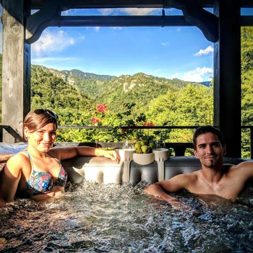 a man and a woman sitting in a hot tub at Holiday Home Raušel in Turke