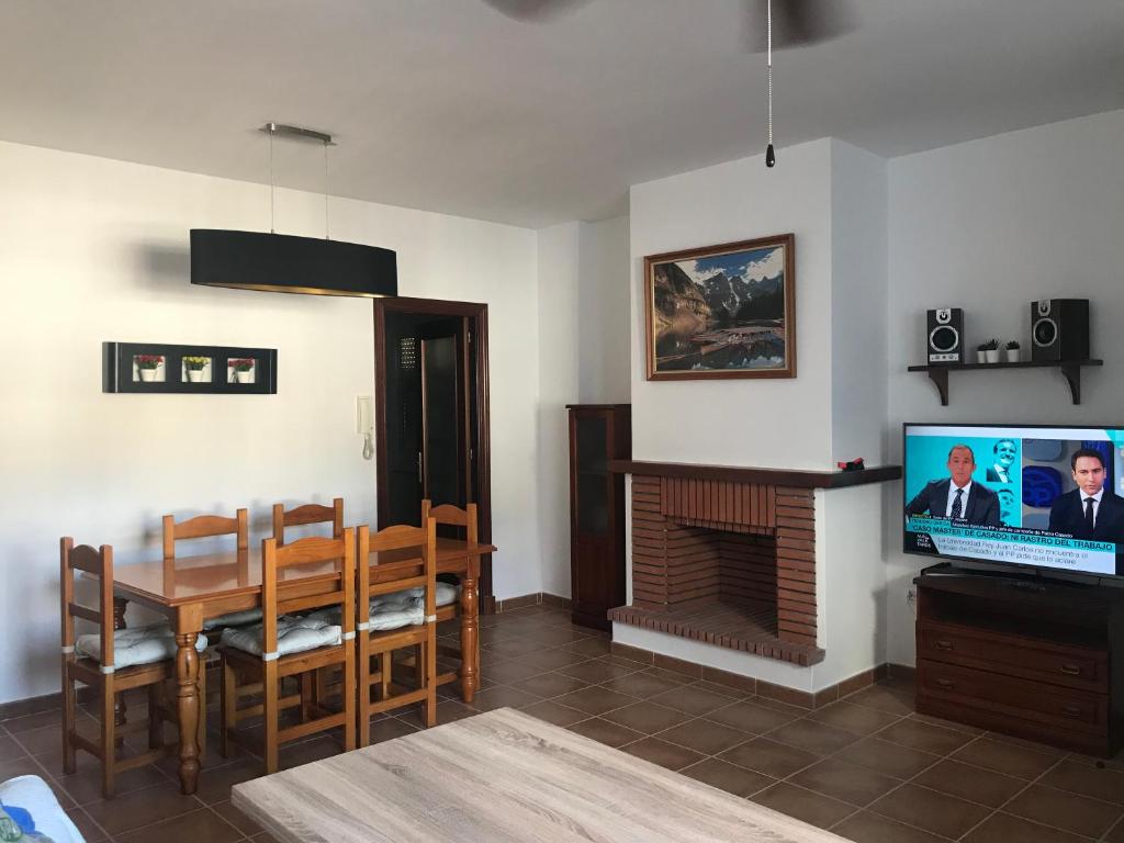 a living room with a dining room table and a television at El Bosque, tu entrada a la Sierra Gaditana. in El Bosque