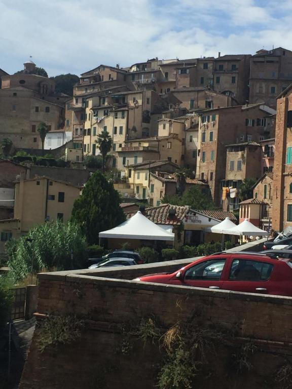 een groep gebouwen op een heuvel met auto's geparkeerd bij Salicotto 56 in Siena