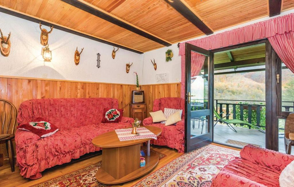 a living room with a red couch and a table at Holiday Home Raušel in Turke