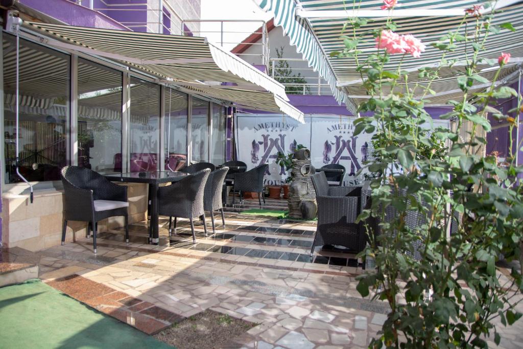 eine Terrasse mit Stühlen und einem Tisch mit Graffiti in der Unterkunft Amethyst House in Otopeni