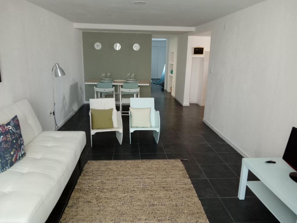 ein Wohnzimmer mit einem weißen Sofa und einem Tisch in der Unterkunft Fisherman's Inn in Montijo