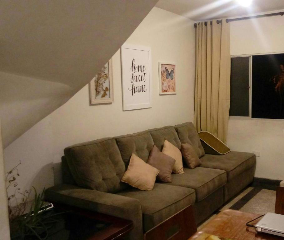 sala de estar con sofá marrón con almohadas en Minha Casa, Seu Hostel, en Recife