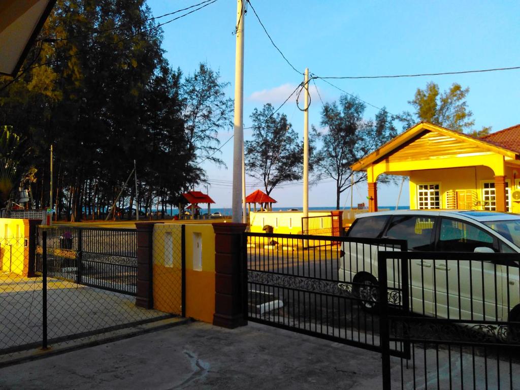 a fence with a car parked in front of a building at Homestay Memori in Dungun
