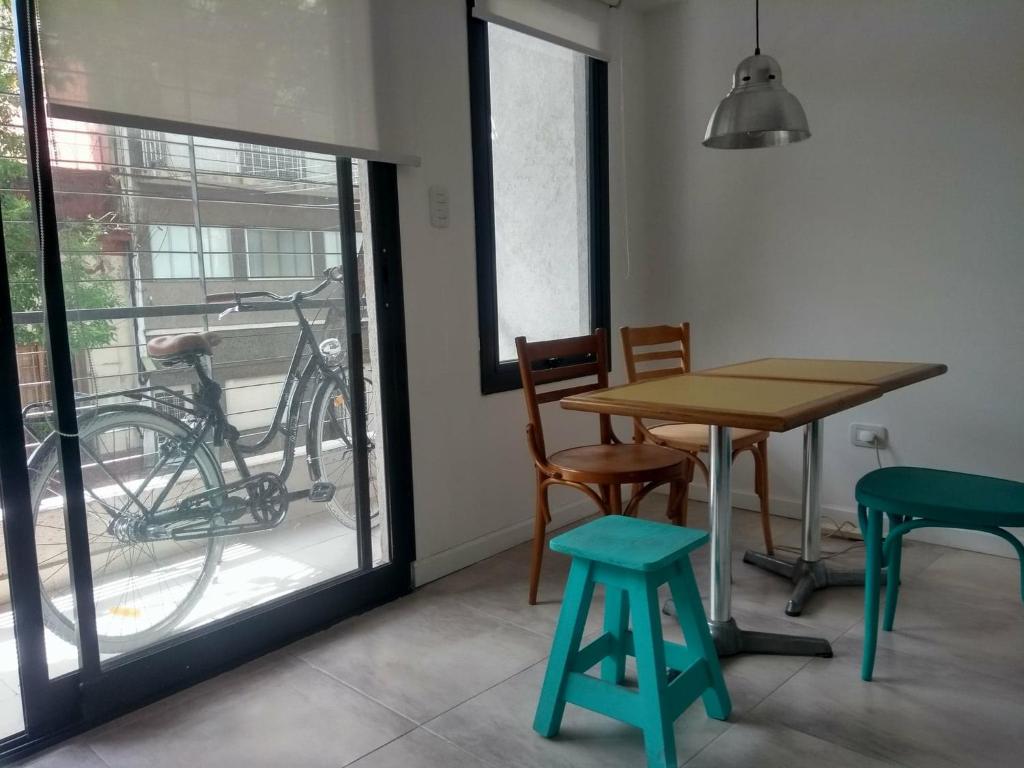 uma sala de jantar com uma mesa e cadeiras e uma bicicleta em Apartamento cómodo y tranquilo con WiFi en Boedo em Buenos Aires