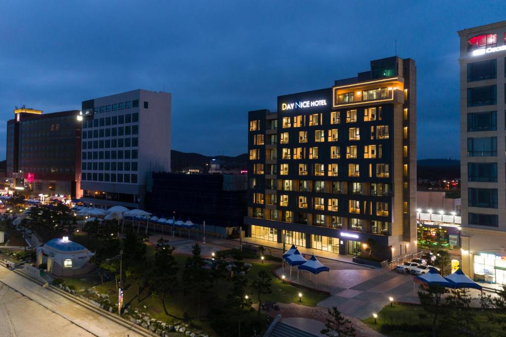 un bâtiment éclairé dans une ville la nuit dans l'établissement Daynice hotel, à Boryeong