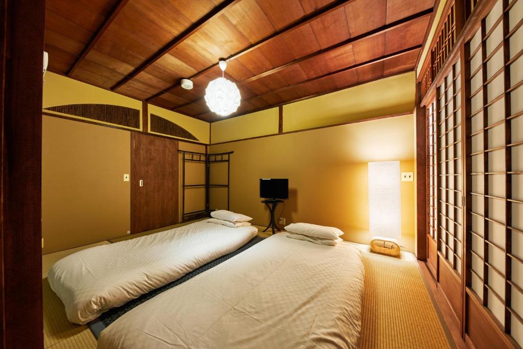 Postel nebo postele na pokoji v ubytování Kyomachiya Hotel Mifuku