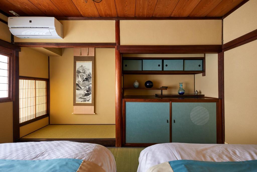 Postel nebo postele na pokoji v ubytování Kyomachiya Hotel Mifuku