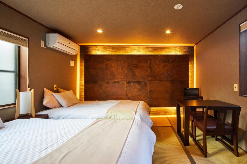 Postel nebo postele na pokoji v ubytování Kyomachiya Hotel Mifuku