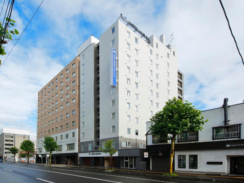 un edificio blanco al lado de una calle en HOTEL MYSTAYS Sapporo Susukino, en Sapporo