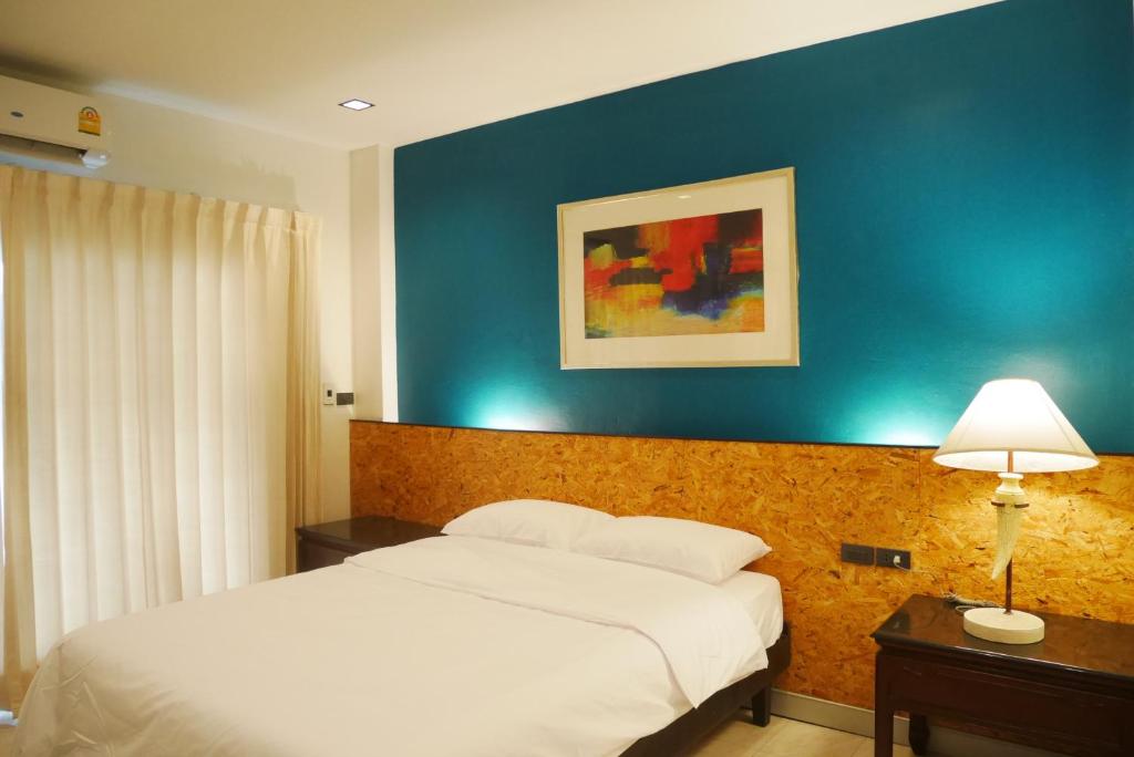 曼谷的住宿－The 92 Residence，一间卧室设有一张床和蓝色的墙壁