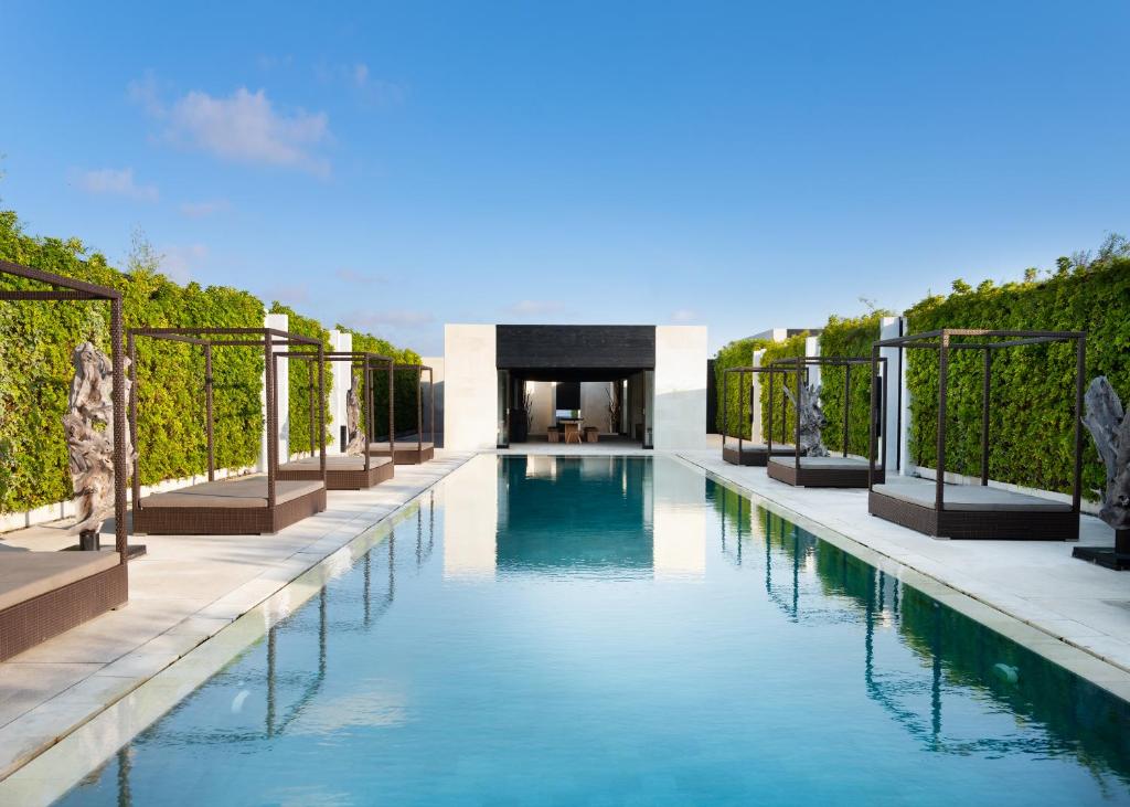 a swimming pool in a villa with vines at eqUILIBRIA Seminyak - CHSE Certified in Seminyak