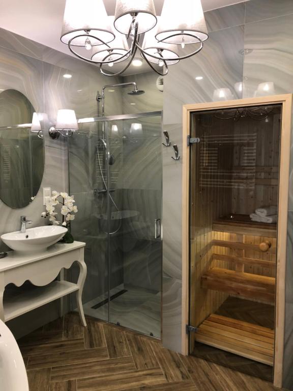 a bathroom with a shower and a sink and a chandelier at Family & Business Sauna Apartments No1 Leśny nad Zalewem Cedzyna Unikat - 3 Bedroom with Private Sauna, Bath with Hydromassage, Terrace, Garage, Catering Options in Kielce