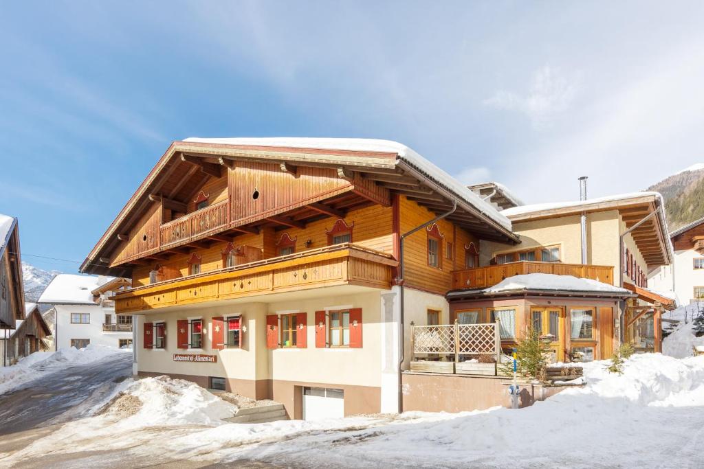 una gran casa de madera en la nieve en Residence Schneiderhof en San Candido