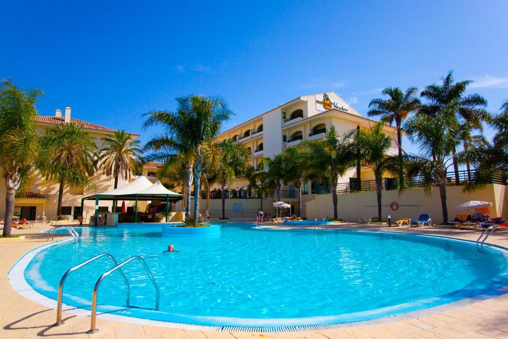a large swimming pool in front of a hotel at Mirachoro Carvoeiro in Carvoeiro