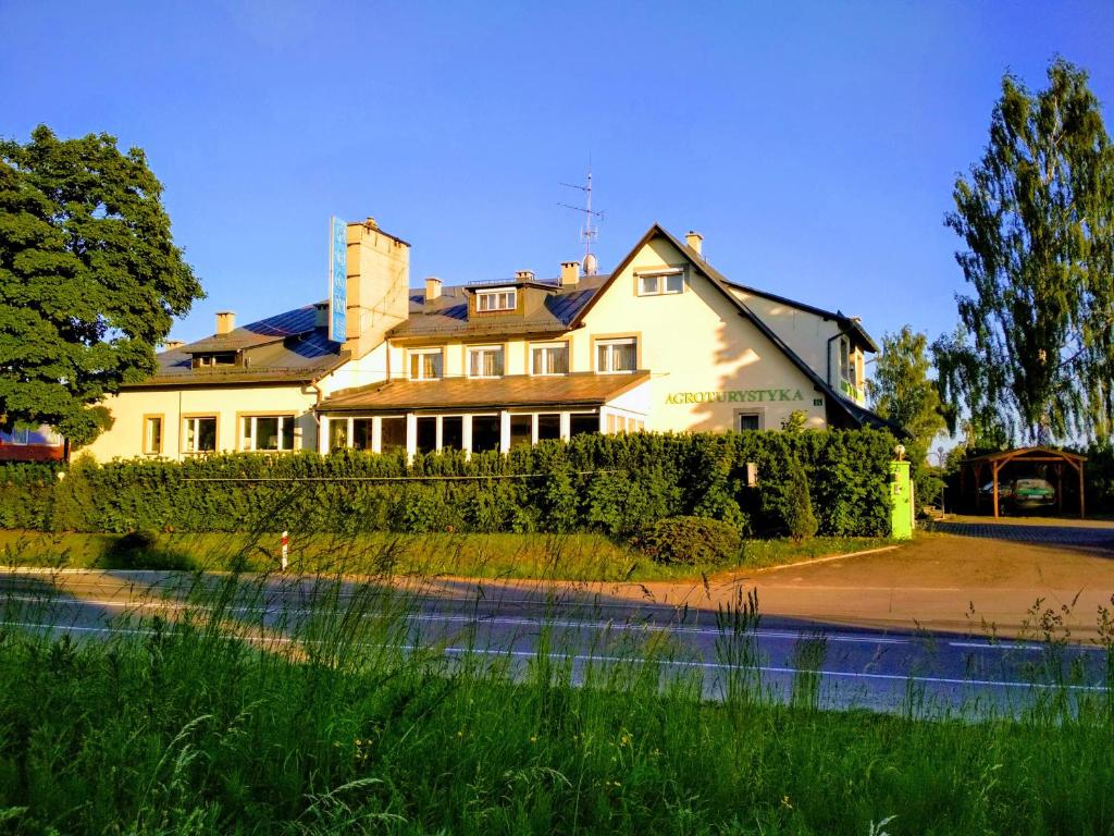 een groot wit huis met een hek ervoor bij Agroturystyka Gramburg in Zblewo