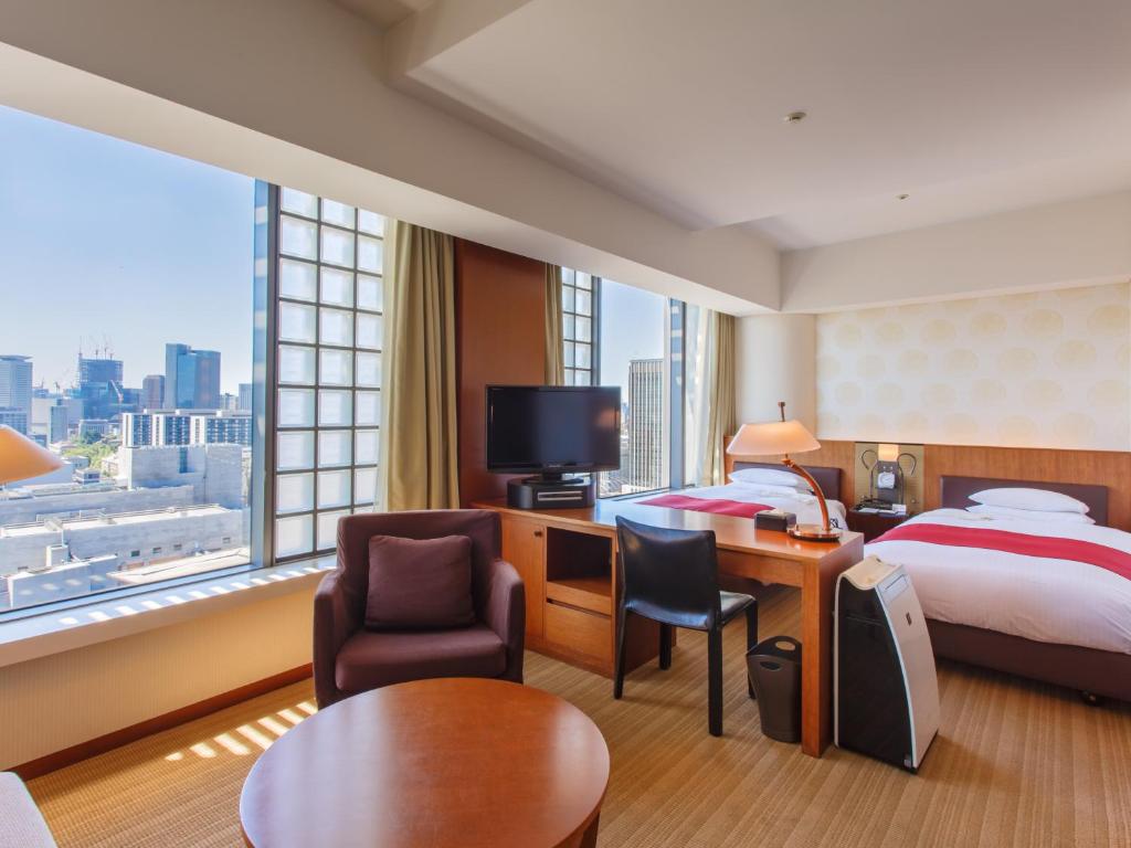 a hotel room with a bed and a desk and chair at Hotel Grand Arc Hanzomon in Tokyo