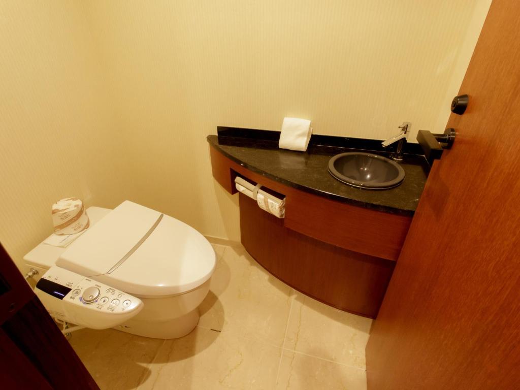 a bathroom with a toilet and a sink at Hotel Grand Arc Hanzomon in Tokyo