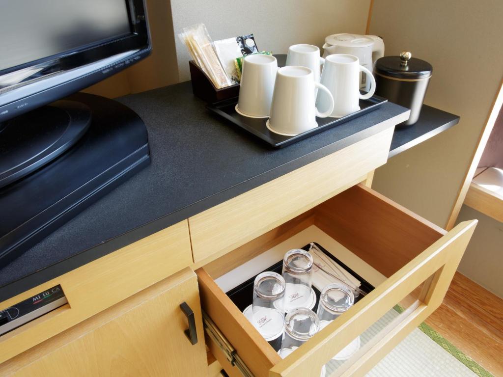 a cupboard with a tray of cups on it at Hotel Grand Arc Hanzomon in Tokyo