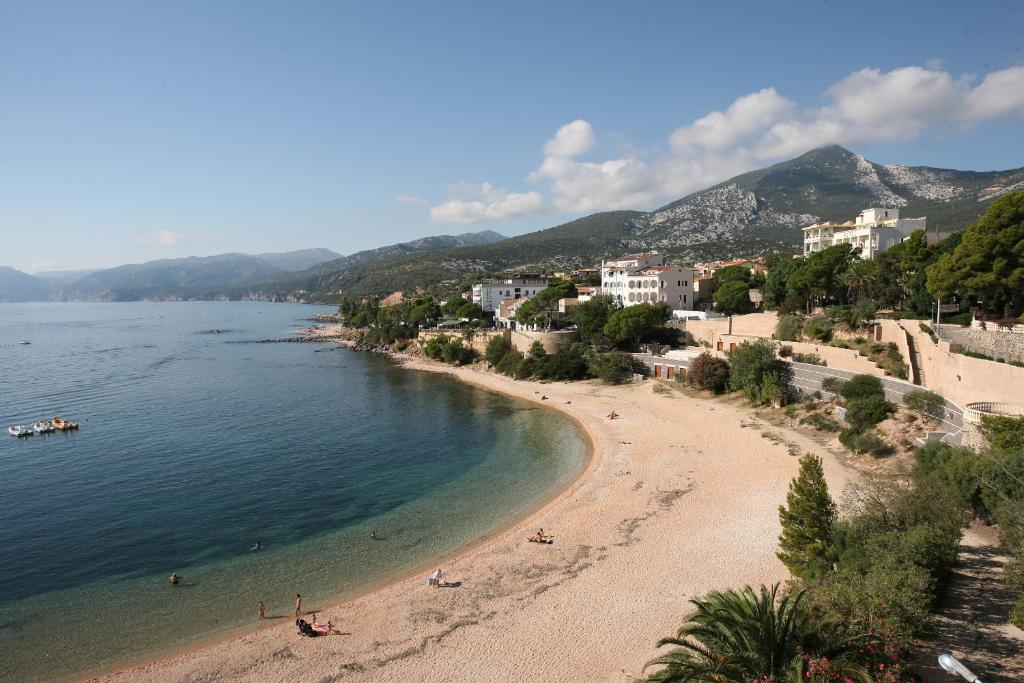 vista su una spiaggia con persone in acqua di Acacia Appartamenti a Cala Gonone