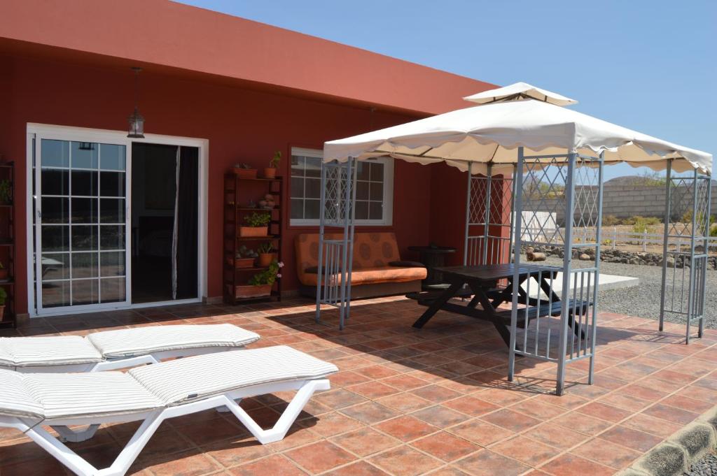 Tuineje的住宿－Estudio Rural La Rosa Herrera，一个带桌子和遮阳伞的庭院