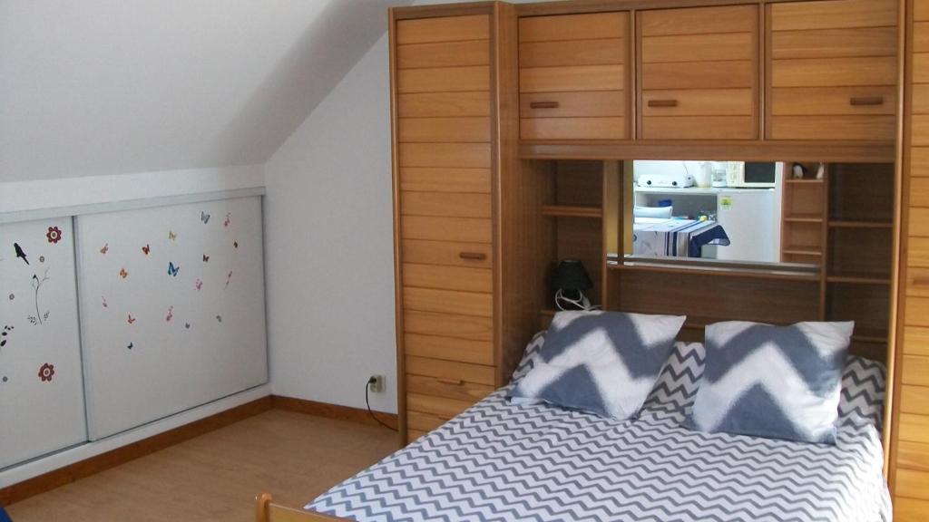 - une chambre avec un lit et une armoire en bois dans l'établissement Gilles Diais, à Louisfert