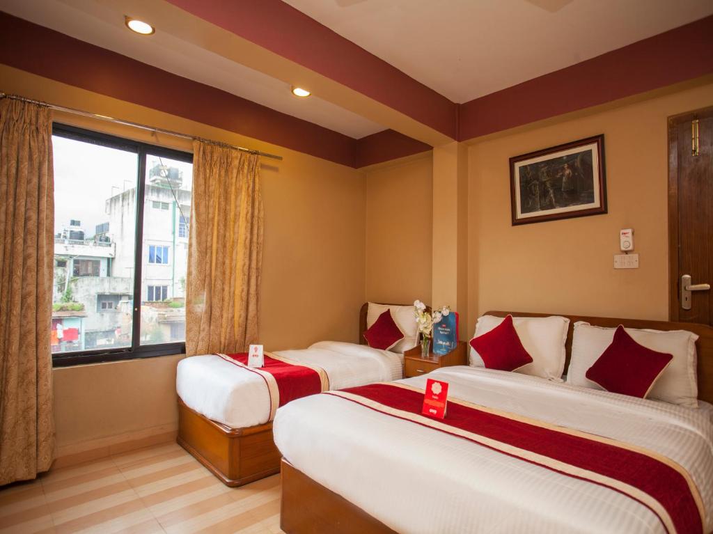 a hotel room with two beds and a window at Shiva Shankar Hotel in Pashupatināth