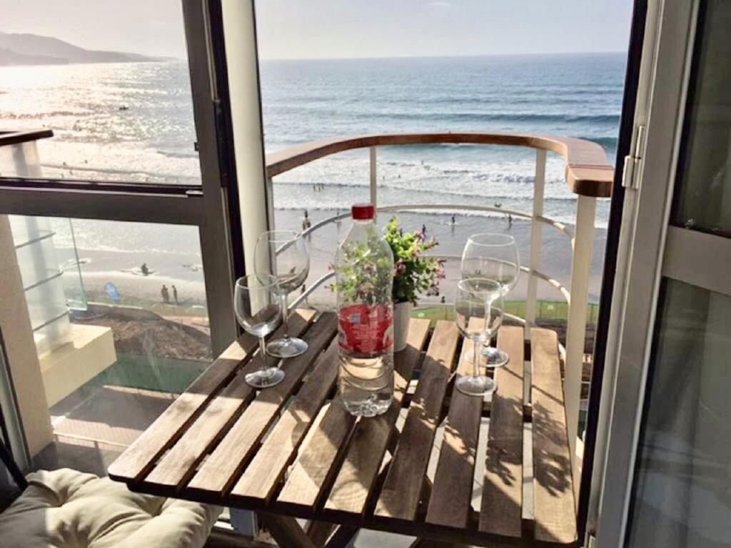 a table on a balcony with a view of the beach at La luz del Alba 3A in Las Palmas de Gran Canaria
