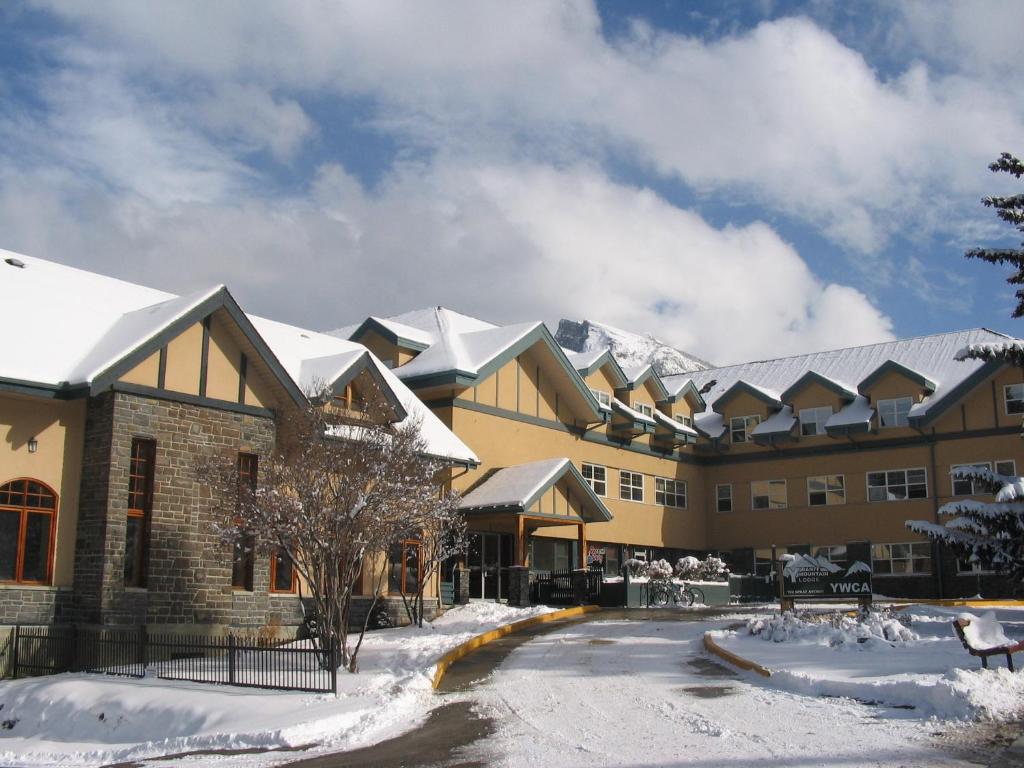 a resort in the snow with mountains in the background at YWCA Banff Hotel in Banff