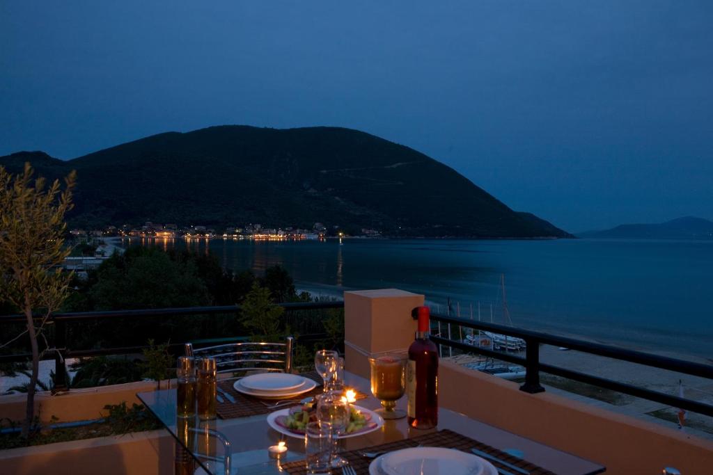 a table with a view of the water at night at Hotel Grand Nefeli in Vasiliki