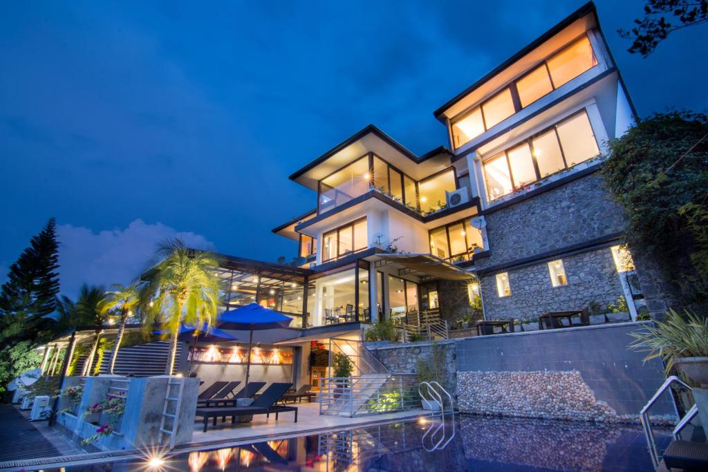 une grande maison avec une piscine en face de celle-ci dans l'établissement The Theva Residency, à Kandy