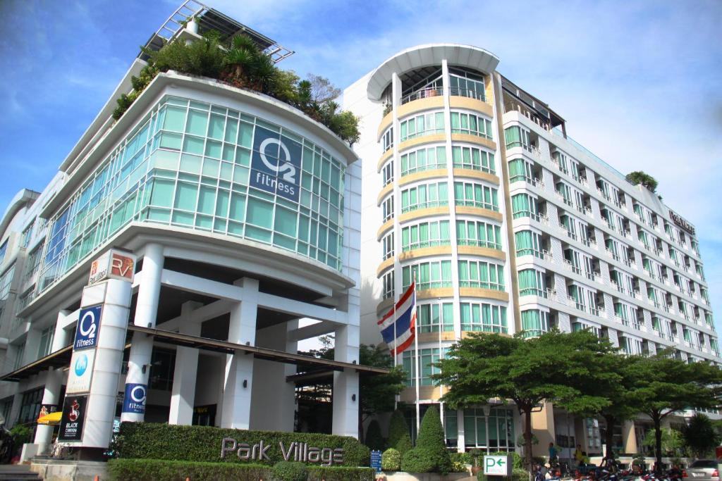 a tall building with a tree on top of it at Park Village Rama II in Bangkok
