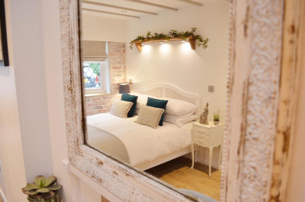 a mirror reflection of a bed in a bedroom at Owl Lodge in Newport Pagnell