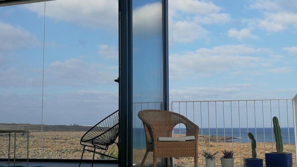een balkon met een stoel en uitzicht op de oceaan bij Salema in Punta de Mujeres