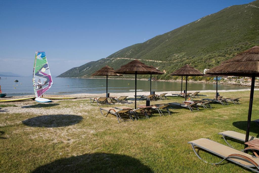 a group of chairs and umbrellas on a beach at Hotel Grand Nefeli in Vasiliki