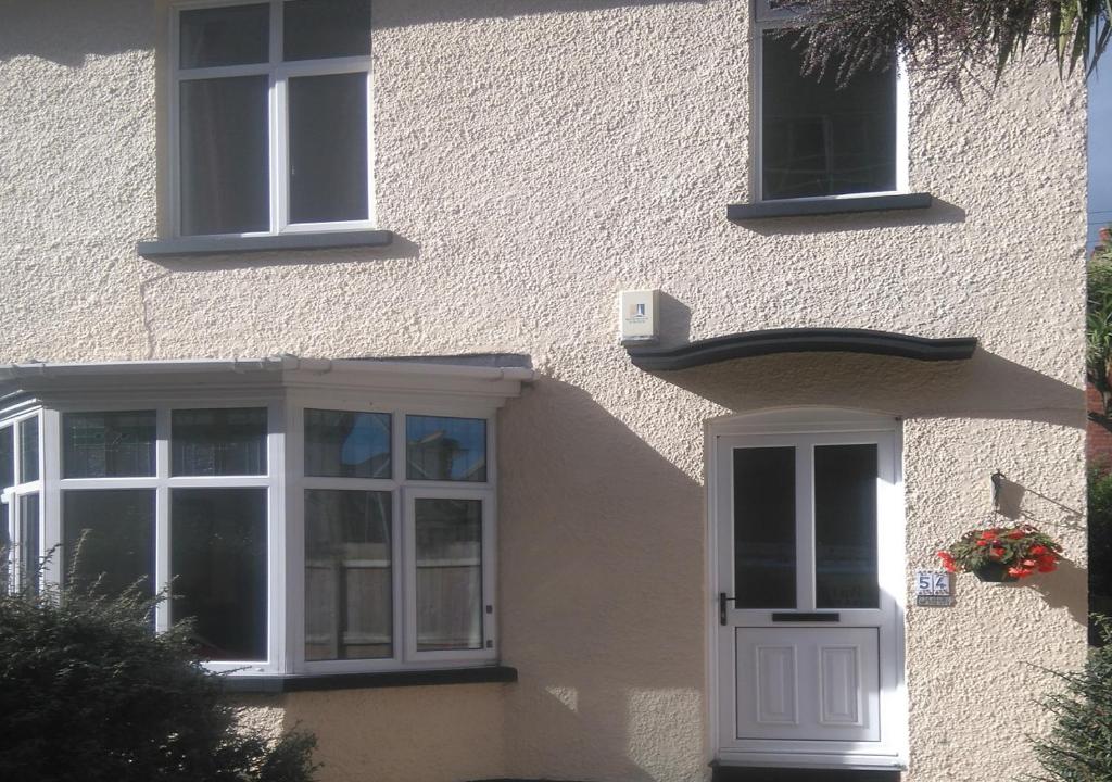 un edificio con una puerta y ventanas blancas en Simon's Cosy House en Bangor
